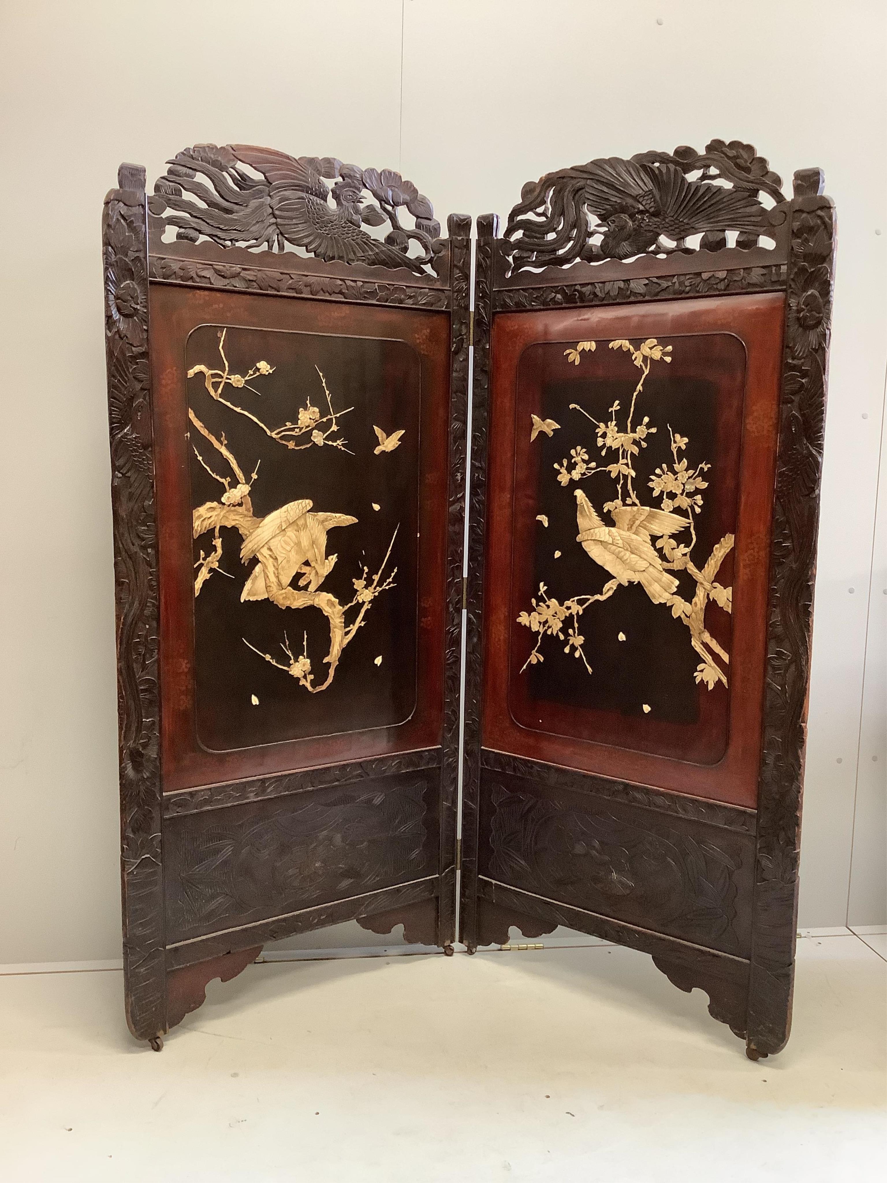 A Japanese carved wood bi-fold screen inset with lacquer and bone ‘eagle’ panels, each panel, width 79cm, height 180cm. Condition - fair